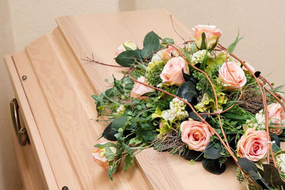 Schöner Sarg mit Trauerschmuck und Blumenschmuck