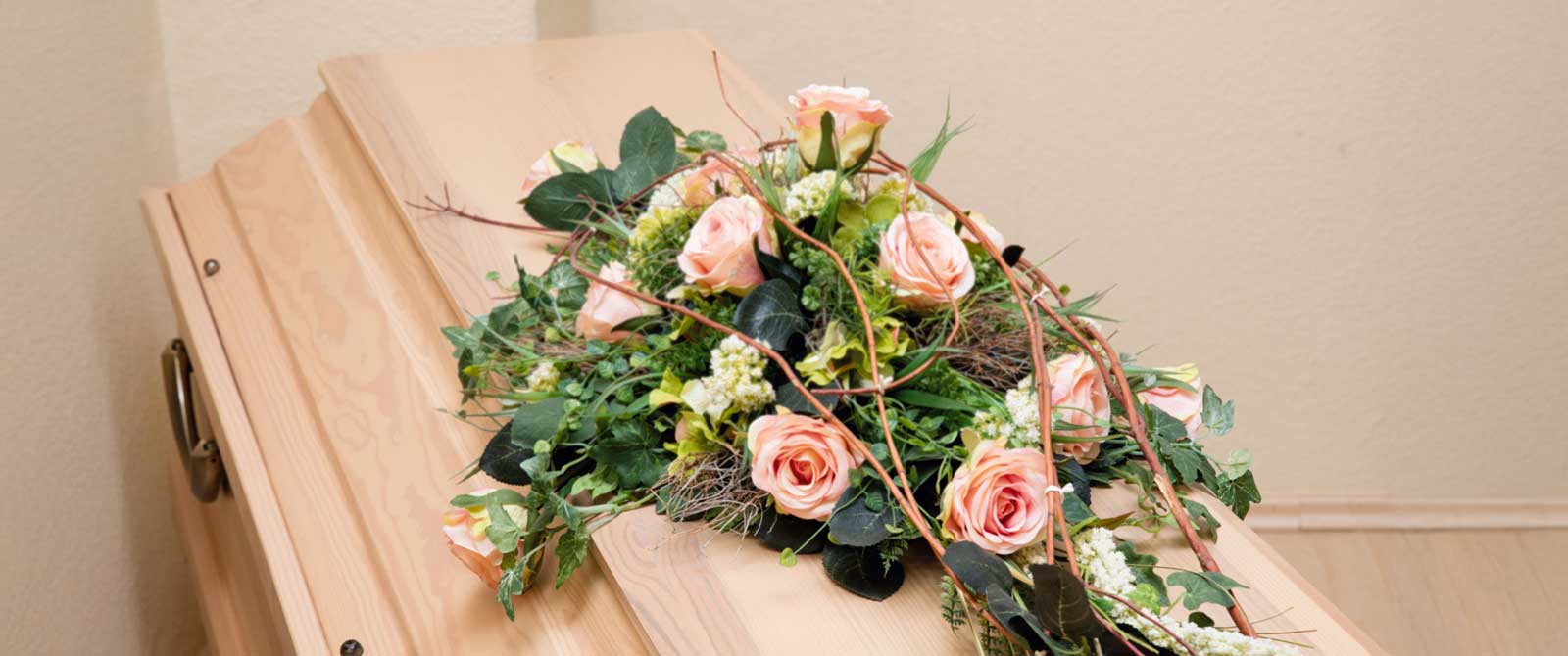 Schöner Sarg mit Trauerschmuck und Blumenschmuck